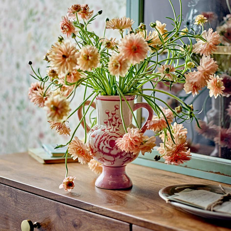 Stylish pink vase with flowers.
